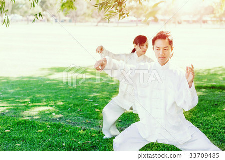 People practicing thai chi in park People practicing thai chi in park 33709485