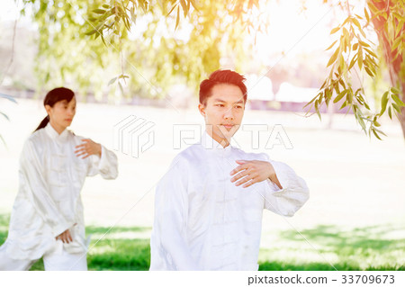 People practicing thai chi in park 33709673