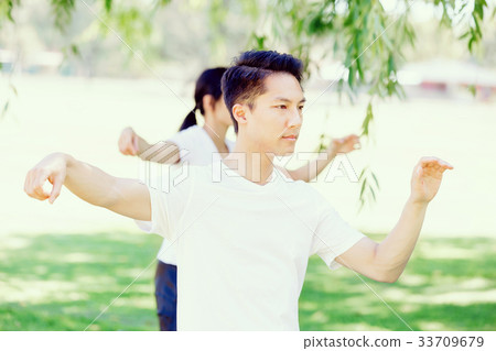 People practicing thai chi in park People practicing thai chi in park 33709679