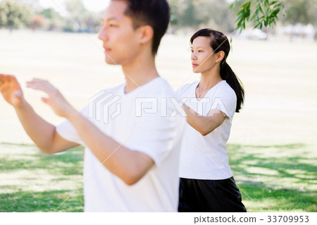 People practicing thai chi in park 33709953