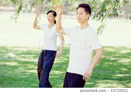 People practicing thai chi in park People practicing thai chi in park 33710032