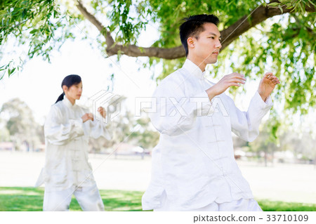 People practicing thai chi in park People practicing thai chi in park 33710109