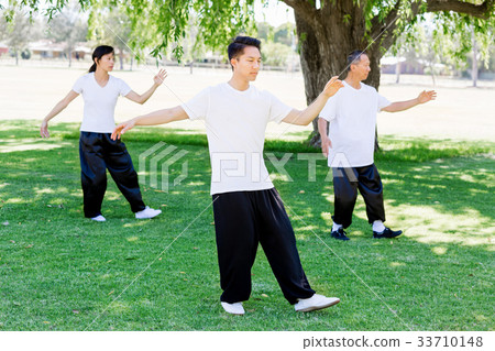 People practicing thai chi in park People practicing thai chi in park 33710148
