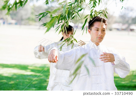 People practicing thai chi in park 33710490