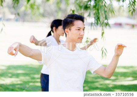 People practicing thai chi in park People practicing thai chi in park 33710556