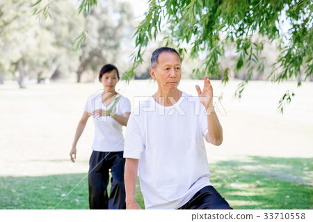 People practicing thai chi in park People practicing thai chi in park 33710558