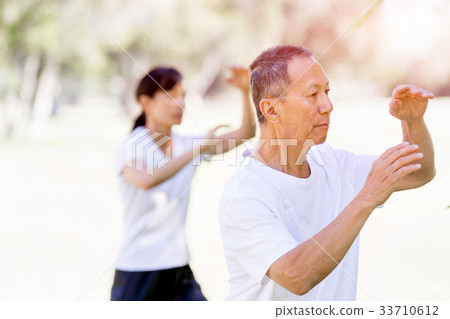 People practicing thai chi in park People practicing thai chi in park 33710612