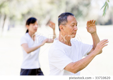 People practicing thai chi in park People practicing thai chi in park 33710620