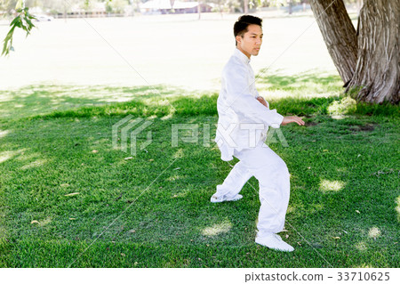 Handsome man practicing thai chi Handsome man practicing thai chi 33710625