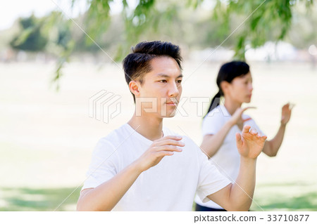 People practicing thai chi in park People practicing thai chi in park 33710877