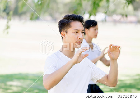 People practicing thai chi in park People practicing thai chi in park 33710879