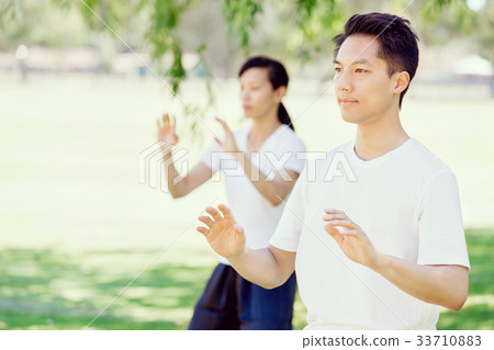 People practicing thai chi in park People practicing thai chi in park 33710883