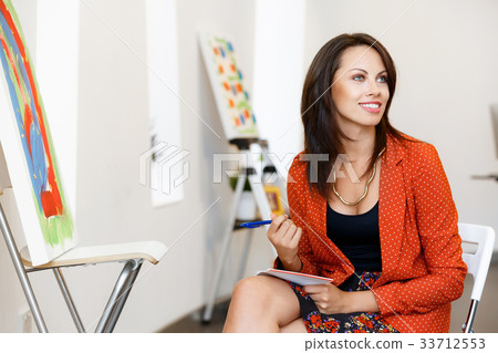 Young caucasian woman standing in art gallery front of paintings Young caucasian woman standing in art gallery front of paintings 33712553