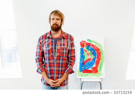 Young male artist standing with a picture 33713259