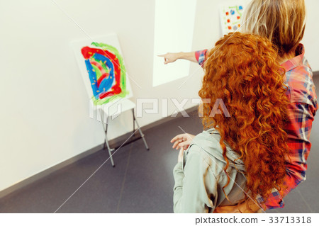 Young caucasian couple standing in a gallery and contemplating artwork Young caucasian couple standing in a gallery and contemplating artwork 33713318