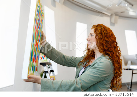 Young female artist with her picture 33713514