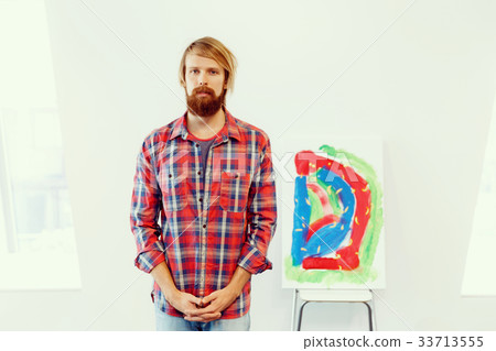 Young male artist standing with a picture 33713555