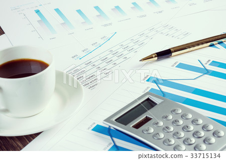 Financial charts and graphs on the table 33715134