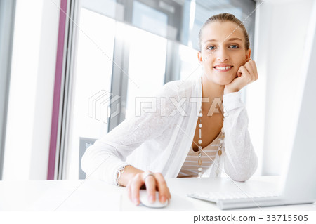 Attractive office worker sitting at desk 33715505