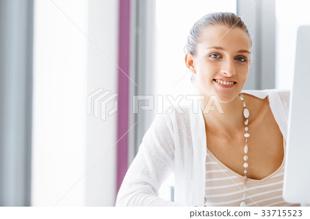Attractive office worker sitting at desk 33715523