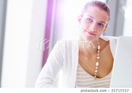 Attractive office worker sitting at desk Attractive office worker sitting at desk 33715537