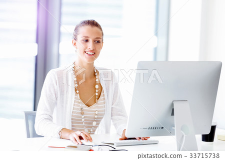 Attractive office worker sitting at desk 33715738