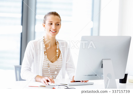 Attractive office worker sitting at desk 33715739