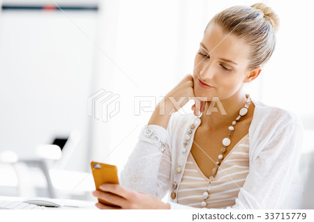 Attractive office worker sitting at desk 33715779