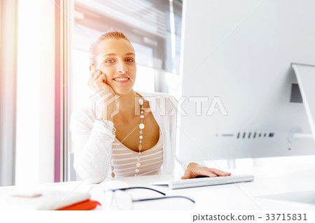 Attractive office worker sitting at desk 33715831