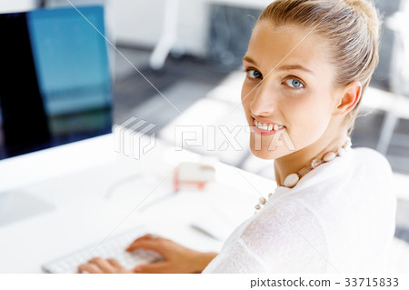 Attractive office worker sitting at desk 33715833