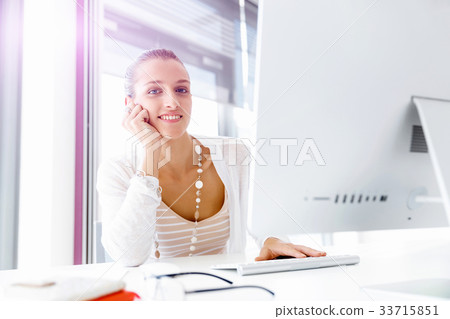 Attractive office worker sitting at desk 33715851
