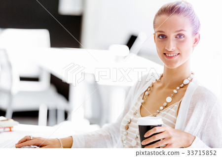 Attractive office worker sitting at desk 33715852