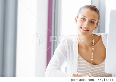 Attractive office worker sitting at desk 33715853