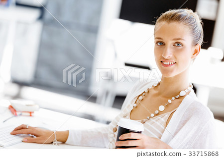 Attractive office worker sitting at desk 33715868