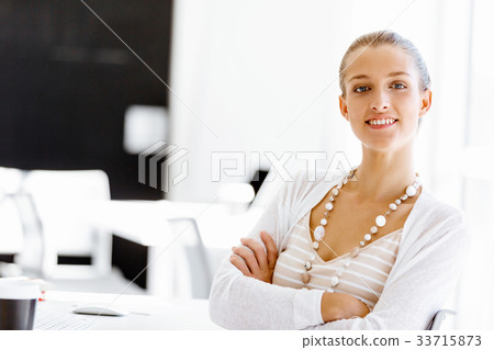 Attractive office worker sitting at desk 33715873