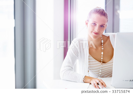 Attractive office worker sitting at desk 33715874