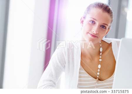 Attractive office worker sitting at desk 33715875