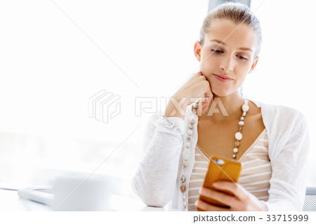 Attractive office worker sitting at desk Attractive office worker sitting at desk 33715999