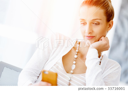 Attractive office worker sitting at desk 33716001
