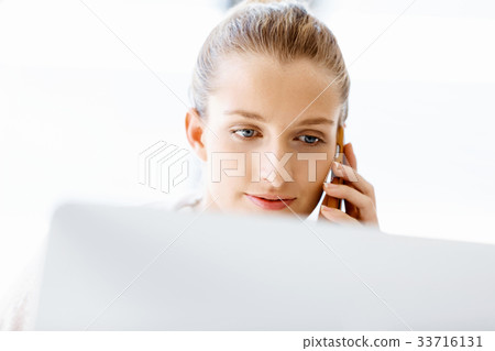 Attractive office worker sitting at desk Attractive office worker sitting at desk 33716131