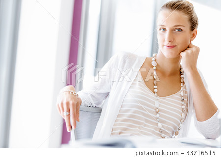 Attractive office worker sitting at desk 33716515