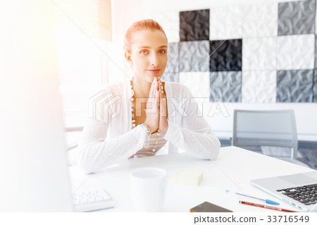 Attractive office worker sitting at desk 33716549