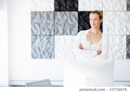 Attractive office worker standing next to window 33716676