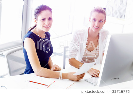 Two female colleagues in office Two female colleagues in office 33716775