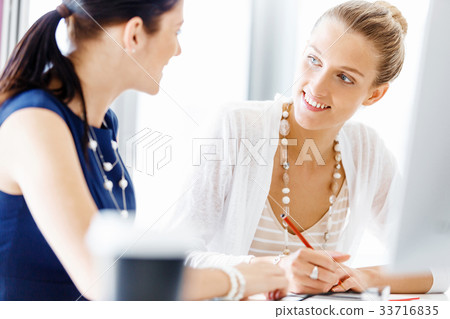 Two female colleagues in office 33716835