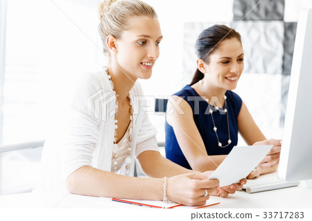 Two female colleagues in office 33717283