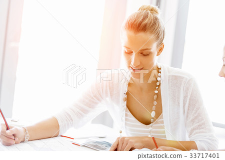 Attractive office worker sitting at desk 33717401