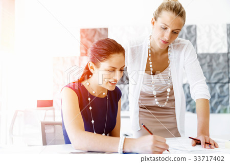 Two female colleagues in office Two female colleagues in office 33717402