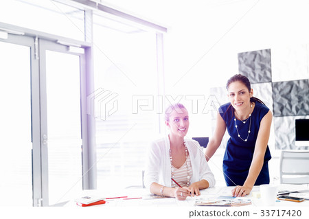 Two female colleagues in office Two female colleagues in office 33717420