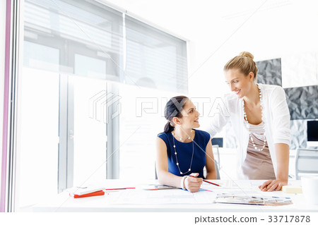 Two female colleagues in office 33717878